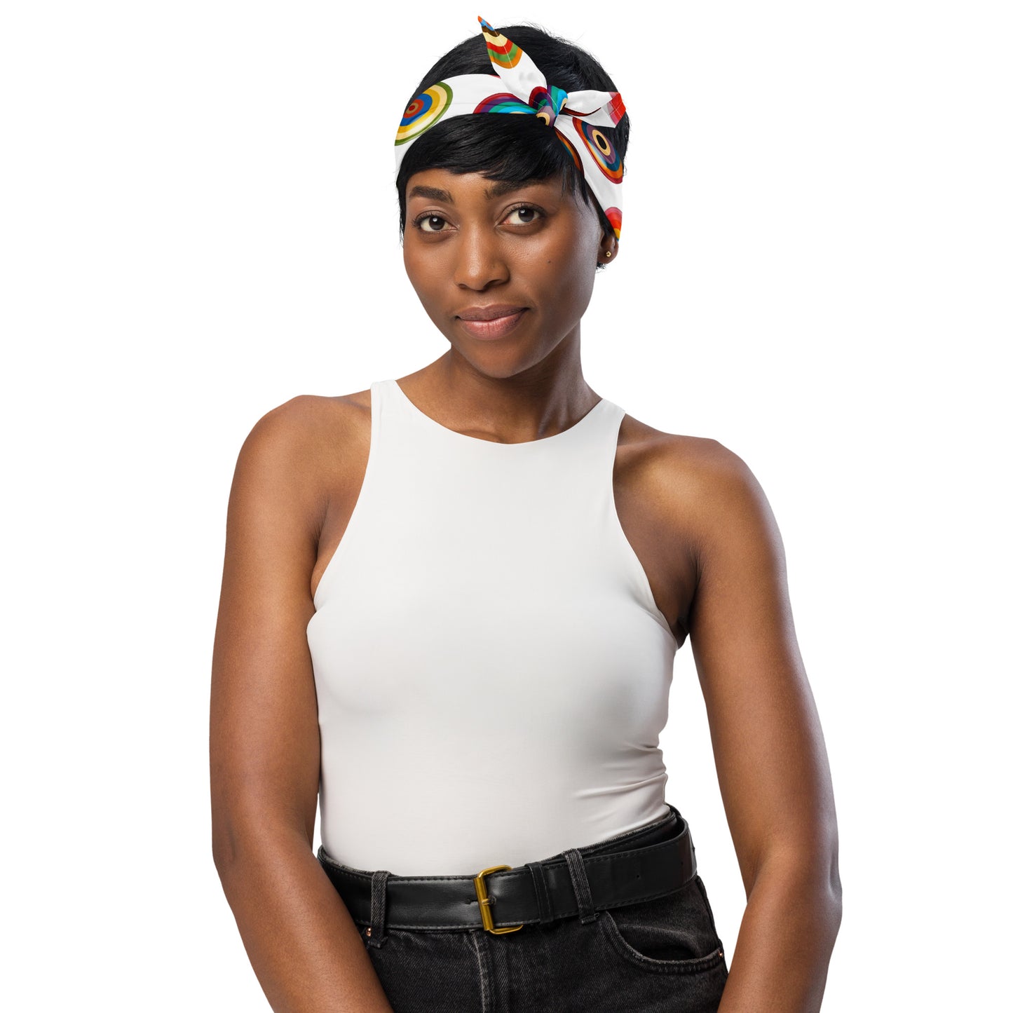 Woman wearing a white tank top and black pants with a colorful headband on a white background