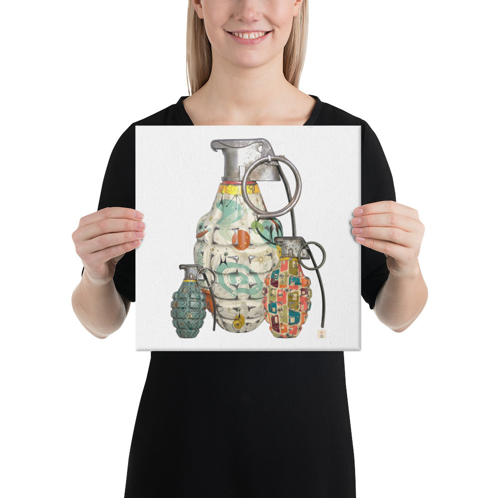 A woman holding a square art print featuring three illustrated hand grenades with colorful mid-century patterns and metallic details on a white background.