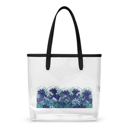 A clear plastic beach tote bag with black shoulder straps and a black top trim, featuring a blue and white wave print on the lower half, shown against a plain white background.